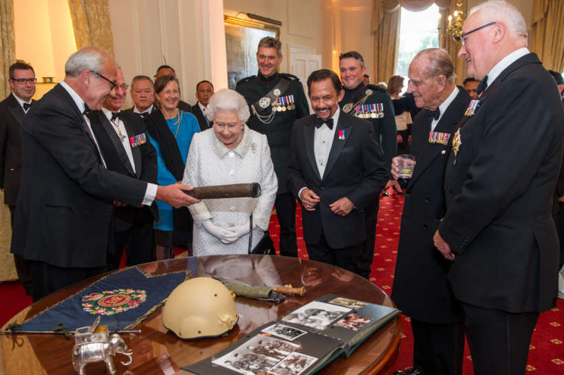 The Queen, the Sultan and Prince Philip being shown articles from the Gurkha Museum